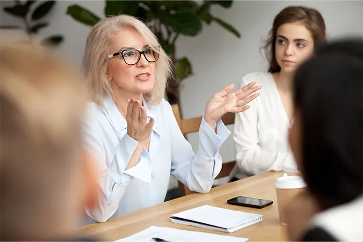 Mehrere Personen in einer Diskussionsrunde an einem Konferenztisch