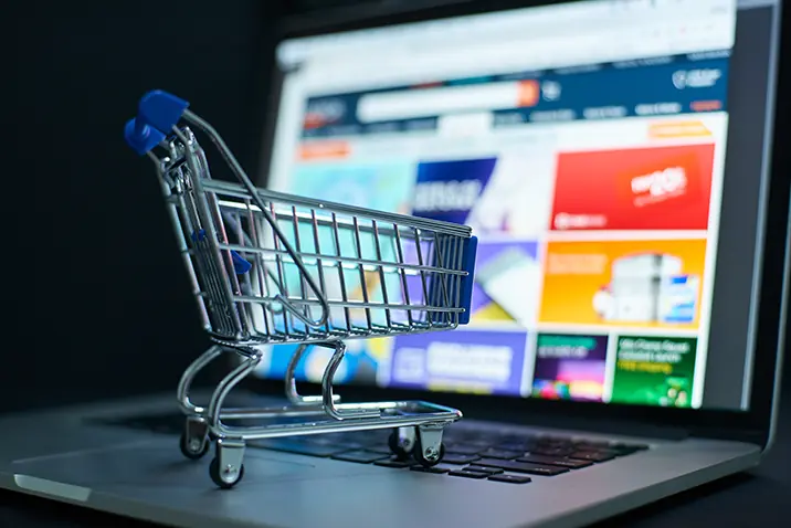 Einkaufswagen steht vor einem Bildschirm mit Online-Shop