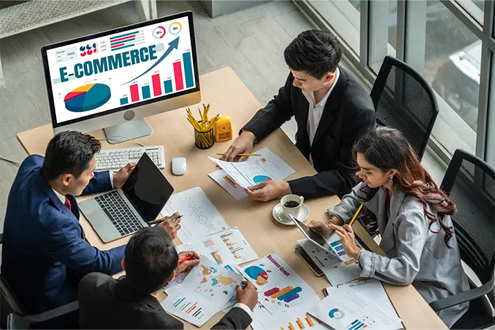 Mehrere Personen analysieren gemeinsam E-Commerce-Kennzahlen an einem Tisch