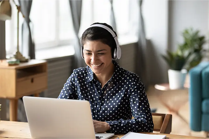 Person mit Headset spricht am Laptop während eines Onlinegesprächs