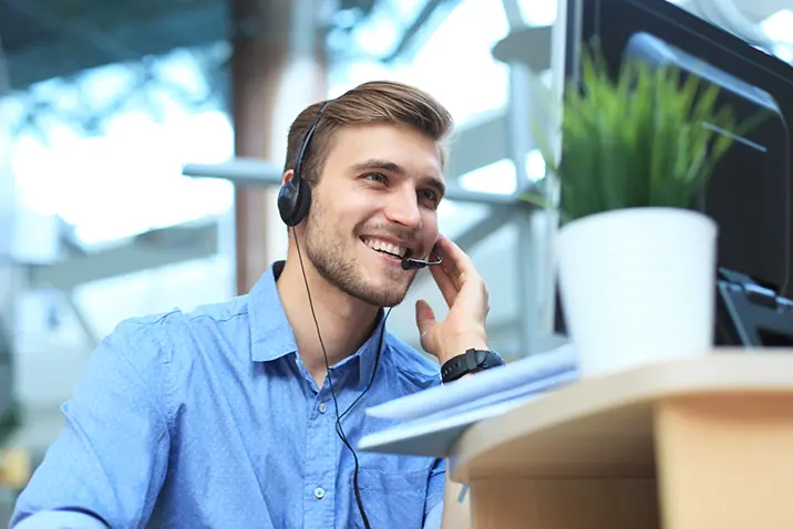 Person mit Headset arbeitet an einem Computerarbeitsplatz im Büro