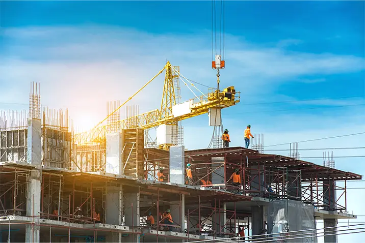 Großbaustelle mit mehreren Personen, Geruesten und einem Baukran bei Hochbauarbeiten