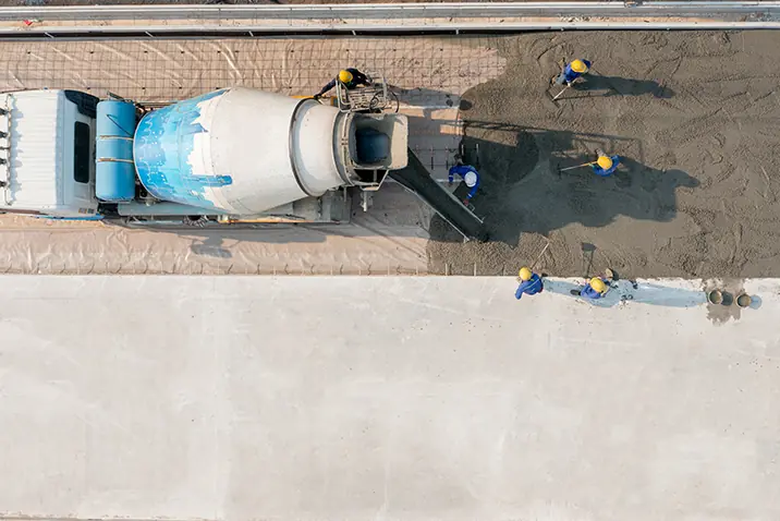 Luftaufnahme eines Betonmischfahrzeugs beim Einbringen von Beton auf einer Baustelle