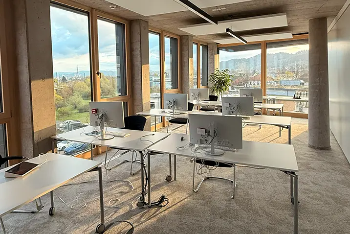 Heller Arbeitsraum mit mehreren Schreibtischen und Blick nach draußen