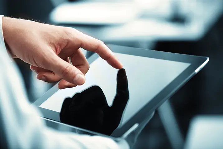 Hand bedient ein Tablet durch Berührung des Displays
