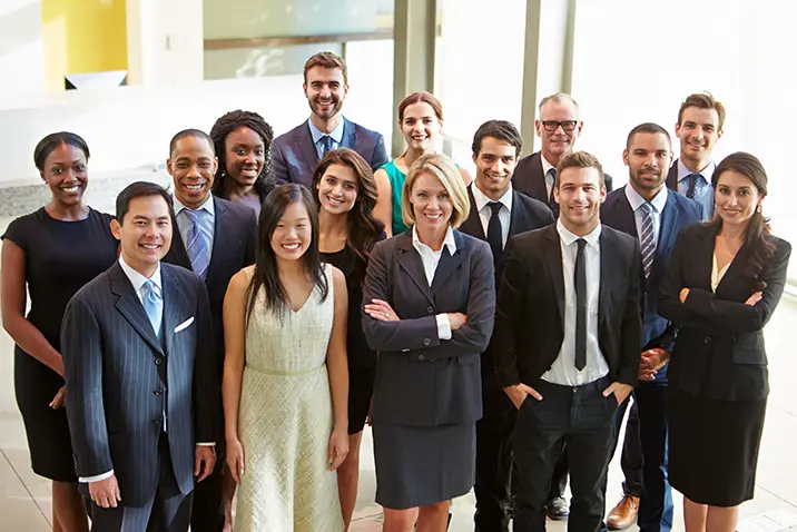 Gruppe von Personen steht gemeinsam in einem professionellen Umfeld