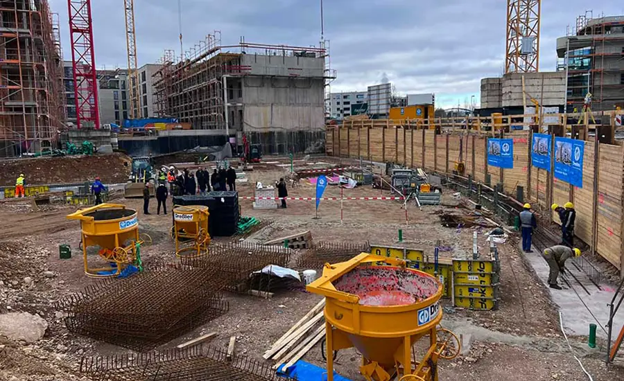 Baustelle mit Baugrube, Kränen und Bauarbeiten im Fortschritt