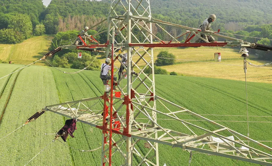 Arbeiten an einer Hochspannungsleitung in ländlicher Umgebung