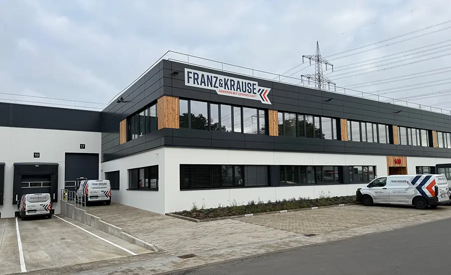 Außenansicht eines modernen Unternehmensgebäudes mit Fahrzeugen