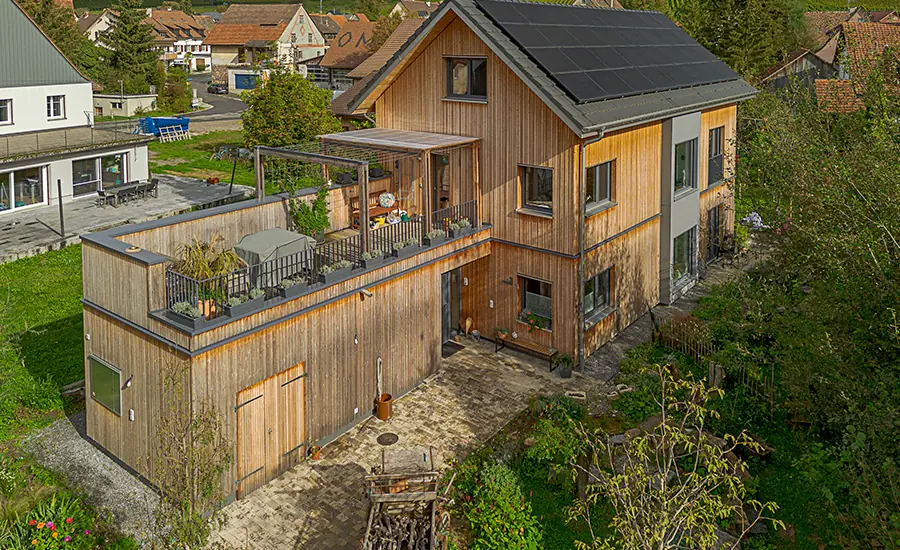 Moderne Holzfassade eines Wohngebäudes mit Terrasse aus der Vogelperspektive