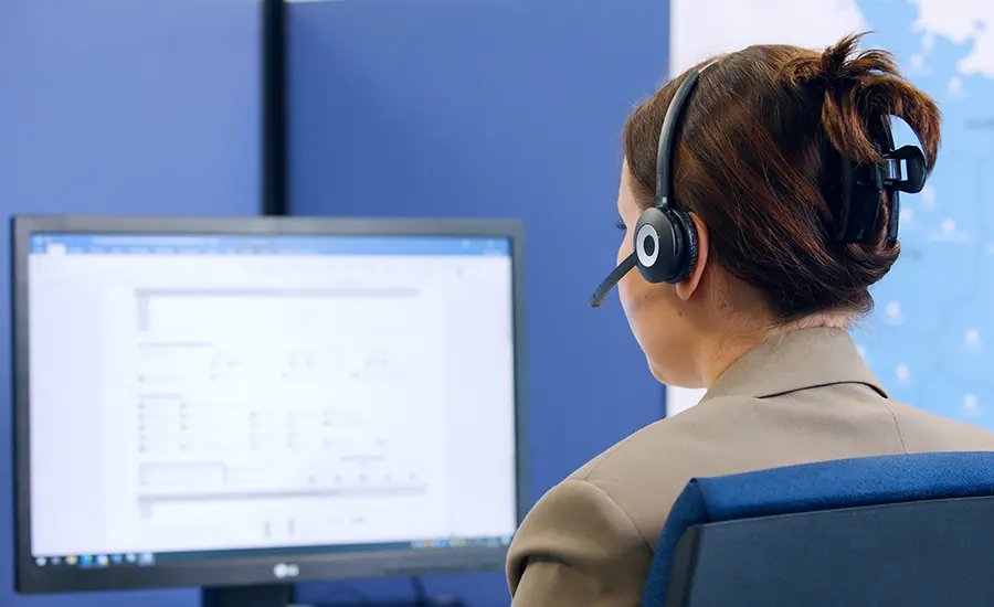 Person mit Headset arbeitet an einem Computerarbeitsplatz