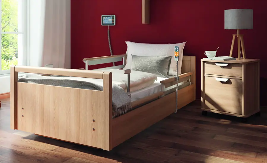 Elektrisches Pflegebett im wohnlichen Zimmer mit Nachttisch und Steuerung von wissner bosserhoff