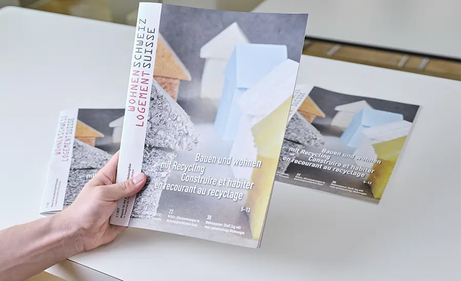 Person hält Publikationen zum Thema Bauen und Wohnen in der Hand