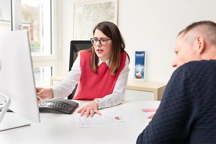 Zwei Personen besprechen Inhalte gemeinsam an einem Schreibtisch